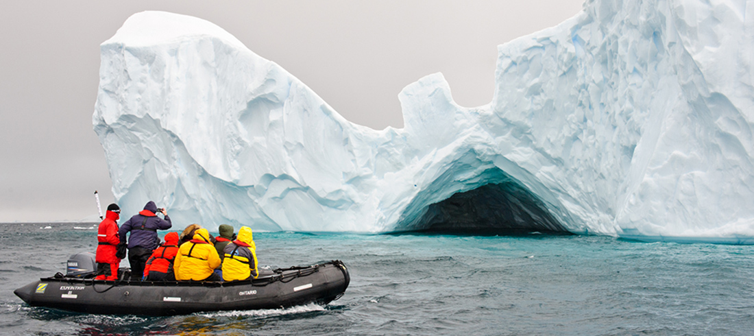 tourists on boat observing iceburg